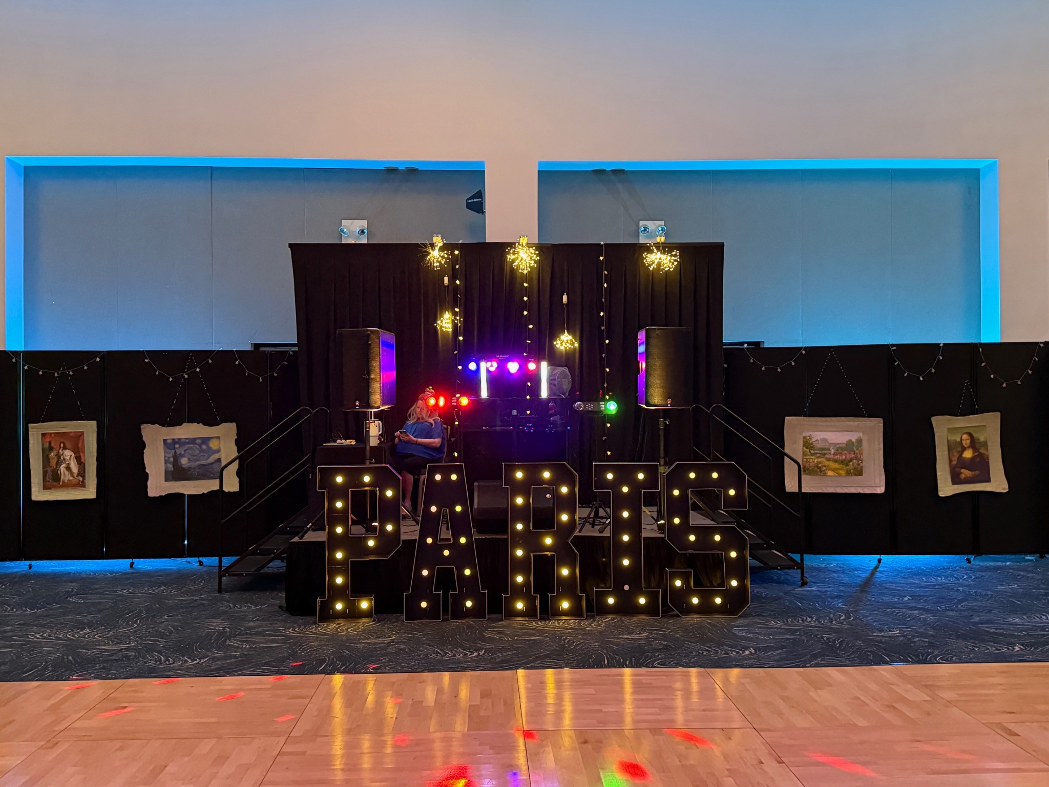 DJ setup with illuminated PARIS letters and decorative lights